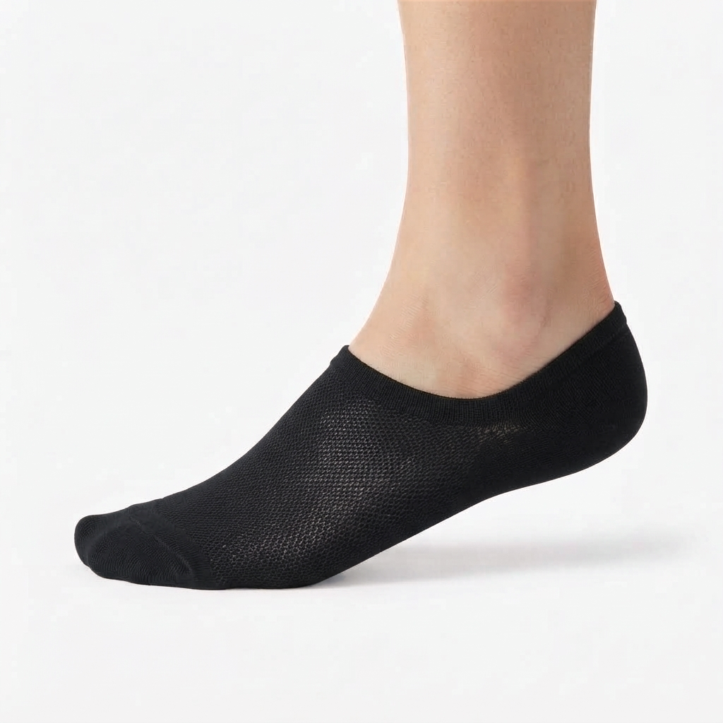 Black FreeTheLace no-show sock worn on a foot, showing the low-cut design that stays hidden inside shoes