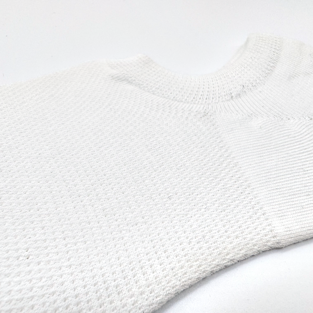 Close-up of the breathable mesh knit on a white FreeTheLace no-show sock